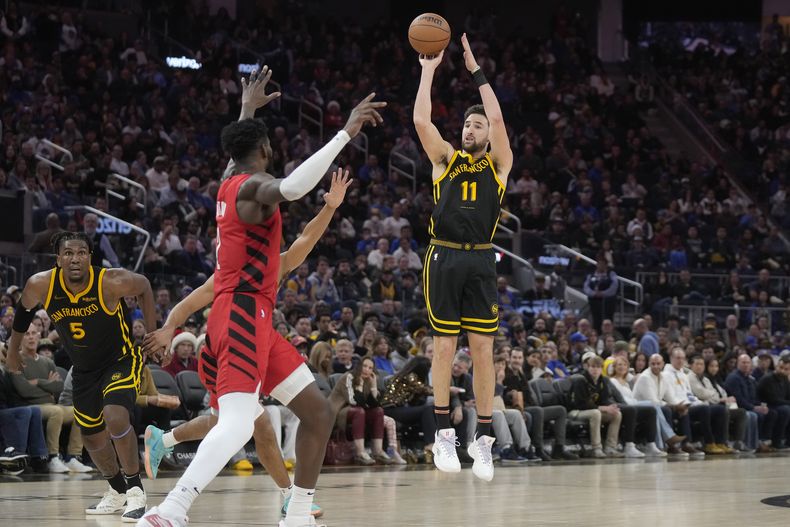 Klay Thompson, de los Warriors de Golden State, intenta un t riple en el encuentro del sábado 23 de diciembre de 2023, ante los Trail Blazers de Portland (AP Foto/Jeff Chiu)