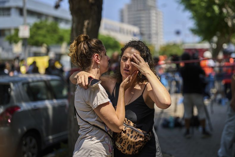 Un grupo de personas cerca de donde cayó un misil en Tel Aviv, Israel, el 22 de junio del 2025. (AP foto/Bernat Armangue)