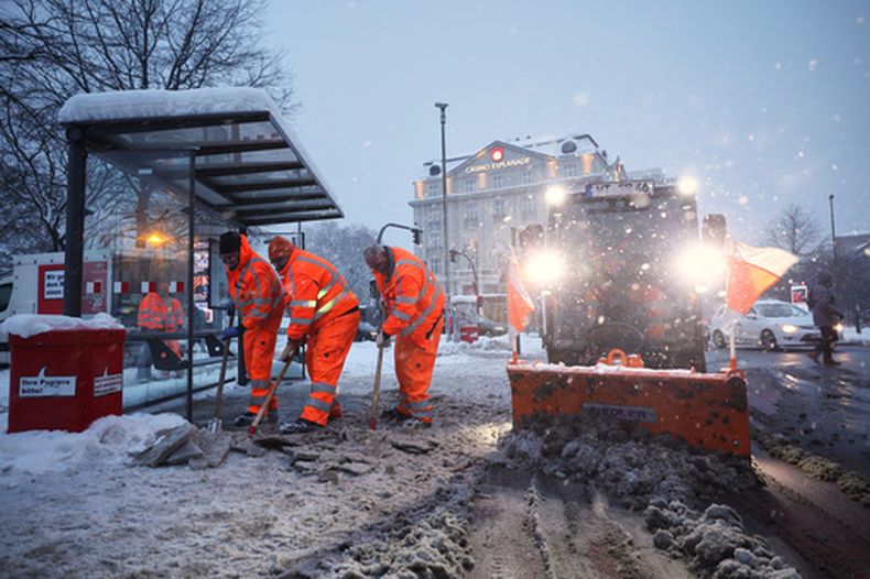 Una cuadrilla de obreros de Hamburgo remueve la nieve de una estación de autobús, el viernes 9 de enero de 2026. (Christian Charisius/dpa vía AP)
