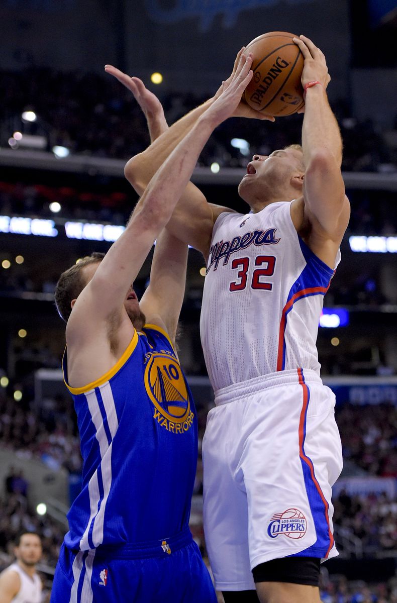 El alero de los Warriors de Golden State David Lee (izquierda) bloquea un disparo de Blake Griffin de los Clippers de Los &Aacute;ngeles en el partido del martes 29 de de abril de 2014. (Foto de AP)