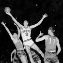 ARCHIVO - En esta foto de archivo del 10 de diciembre de 1957, Bob Pettit, de los Hawks de St. Louis, salta para realizar un disparo a una mano, pero falla en el intento de anotar durante el primer cuarto de un partido de baloncesto de la NBA contra los Royals de Cincinnati en el Madison Square Garden, en la ciudad de Nueva York. Bloqueando a Pettit se encuentra Dick Ricketts (24), de los Royals, mientras Jim Paxson (11) observa la jugada. (Foto AP/Archivo)