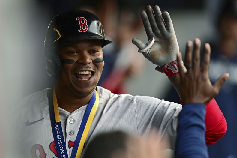 El dominicano Rafael Devers, de los Medias Rojas de Boston, festeja en la cueva luego de batear un jonrón en el juego del miércoles 24 de abril de 2024, ante los Guardianes de Cleveland (AP Foto/David Dermer)