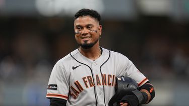 Luis Arraez, de los Gigantes de San Francisco, bromea con jugadores en la cueva de los Padres de San Diego mientras se encuentra en la primera base tras ser golpeado por un lanzamiento durante la cuarta entrada de un partido de béisbol el jueves 30 de julio de 2026, en San Diego. (Foto AP/Gregory Bull)