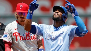 Starling Marte (0), de los Reales de Kansas City, reacciona cerca de Bryson Stott (5), segunda base de los Filis de Filadelfia, después de batea un doble productor durante la primera entrada del juego de béisbol de Grandes Ligas el lunes 6 de julio de 2026, en Kansas City, Missouri. (AP Foto/Colin E. Braley)