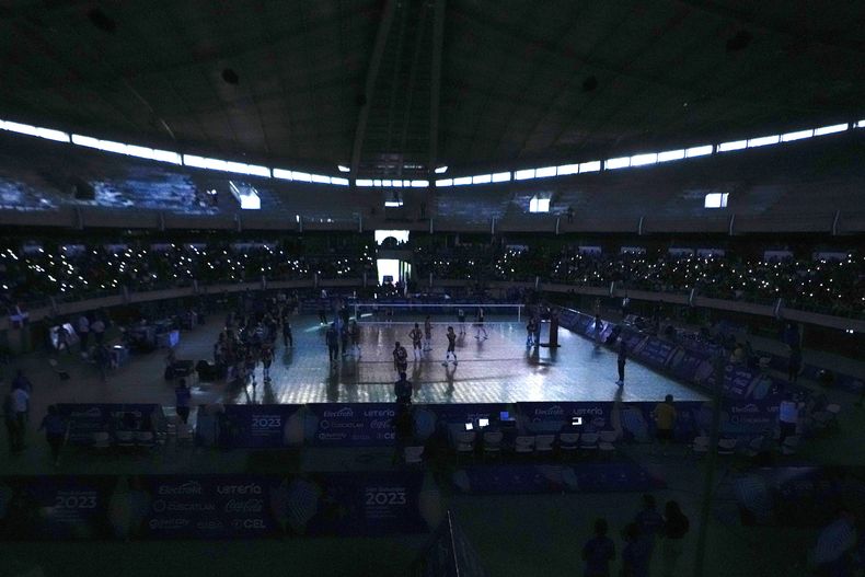 Espectadores toman fotos con sus celulares durante la final de voleibol de mujeres en los Juegos Centroamericanos y del Caribe de San Salvador, el sábado 8 de julio de 2023 (AP Foto/Arnulfo Franco)