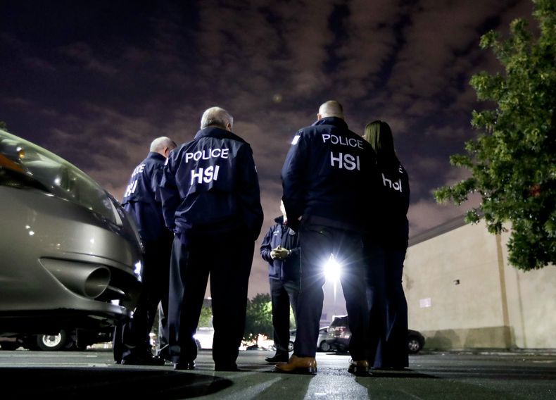 Agentes de inmigración se preparan para entregar una advertencia sobre prácticas de empleo a una tienda 7-Eleven en Los Ángeles el 10 de enero del 2018. (AP foto/Chris Carlson)