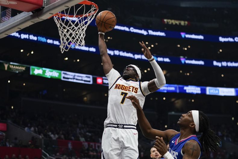 Reggie Jackson (izquierda), de los Nuggets de Denver, ante Terance Mann, de los Clippers de Los Ángeles, durante la primera mitad del juego de la NBA que enfrentó a ambos equipos, el 27 de noviembre de 2023, en Los Ángeles. (AP Foto/Ryan Sun)