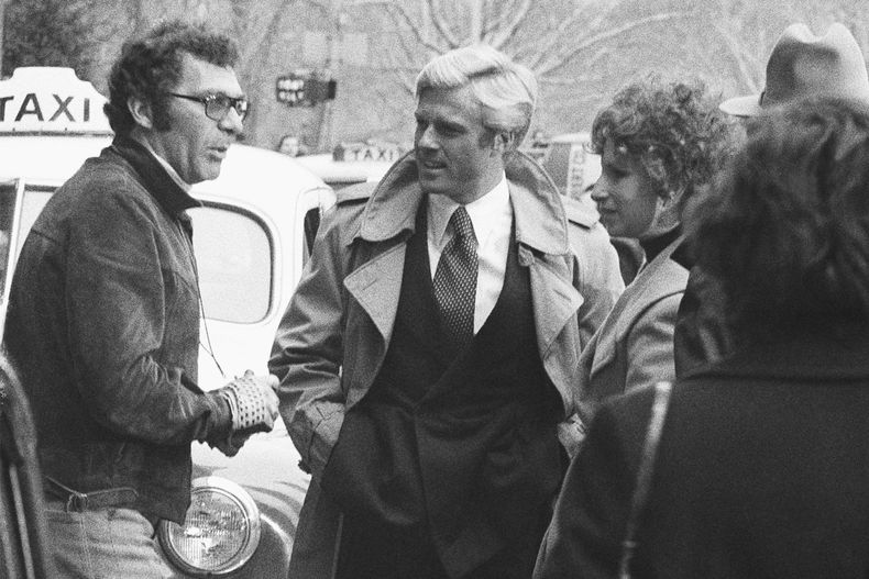 ARCHIVO - El director Sydney Pollack, a la izquierda, con los actores Robert Redford, centro, y Barbra Streisand durante el rodaje de The Way We Were en Nueva York el 28 de noviembre de 1972. (Foto AP/Marty Lederhandler, archivo)