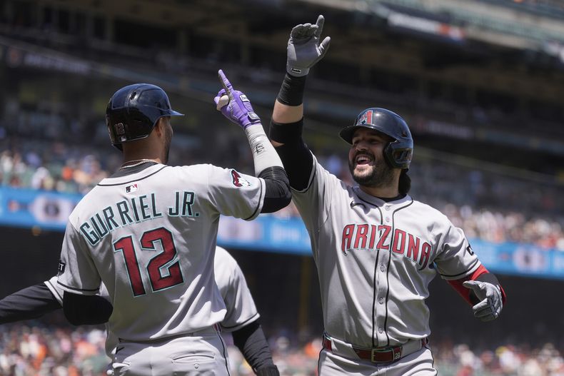 Eugenio Suárez, derecha, de los Diamondbacks de Arizona, celebra después de batear un jonrón de tres carreras que se llevó por delante a Lourdes Gurriel Jr. (12) y a Josh Naylor durante la tercera entrada del juego de béisbol de Grandes Ligas contra los Gigantes de San Francisco, el miércoles 14 de mayo de 2025, en San Francisco. (AP Foto/Jeff Chiu)