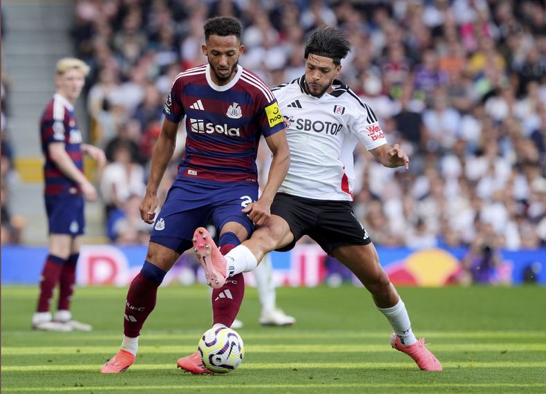 Lloyd Kelly del Newcastle United pelea por el balón con el mexicano Raúl Jiménez del Fulham en el encuentro de la Liga Premier el sábado 21 de septiembre del 2024. (Jonathan Brady/PA via AP)