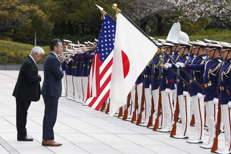 El ministro japonés de Defensa Gen Nakatani, a la izquierda, y el secretario estadounidense de Defensa, Pete Hegseth, pasan revista a una guardia de honor durante una ceremonia de bienvenida en el Ministerio de Defensa de Tokio el domingo 30 de marzo de 2025. (Kiyoshi Ota/Pool Foto via AP)