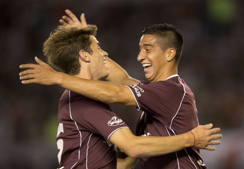 Diego Gonzalez (derecha), del Lan&uacute;s, celebra con su compa&ntilde;ero Lucas melano despu&eacute;s de anotar un tanto contra River Plate, en un partido de la Copa Sudamericana, realizado el mi&eacute;rcoles 6 de noviembre de 2013  (AP Foto/Eduardo Di