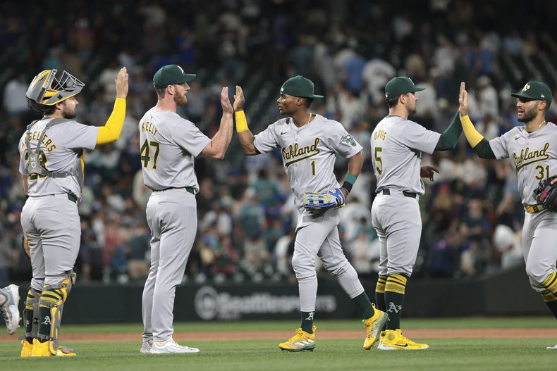 Shea Langeliers, Michael Kelly, Esteury Ruiz, J.D. Davis y Abraham Toro, de izquierda a derecha, celebran después de la victoria del equipo 8-1 sobre los Marineros de Seattle en el partido de béisbol el sábado 11 de mayo de 2024, en Seattle. (AP Foto/Jason Redmond)