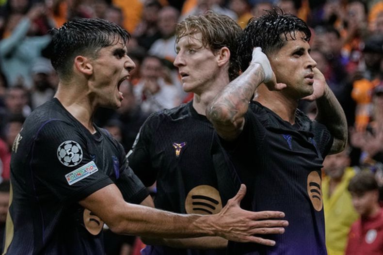 Joao Cancelo (derecha) celebra tras anotar el primer gol del Barcelona ante Galatasaray en la Liga de Campeones, el martes 13 de octubre de 2026, en Estambul. (AP Foto/Khalil Hamra)