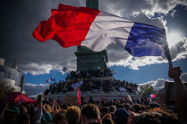 Un individuo alza una bandera de Francia durante una protesta por el financiamiento escolar, el jueves 8 de octubre de 2026, en París. (AP Foto/Aurelien Morissard)