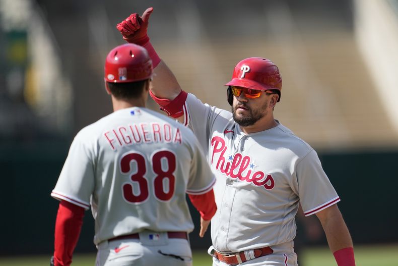 Kyle Schwarber (derecha) de los Filis de Filadelfia tras impulsar una carrera en el 12do inning ante los Atléticos de Oakland, el sábado 17 de junio de 2023, en Oakland. (AP Foto/Jeff Chiu)