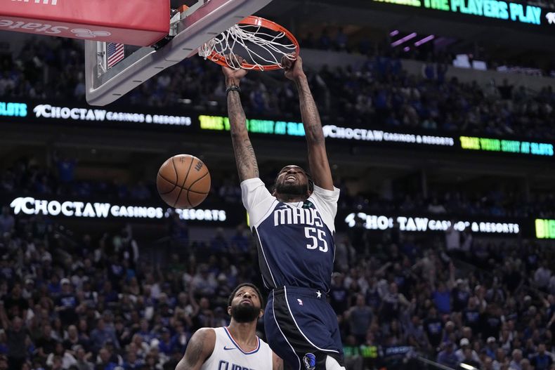 Derrick Jones Jr. de los Mavericks de Dallas clava el balón frente a Paul George de los Clippers de Los Ángeles en el juego de la serie de primera ronda de la postemporada el viernes 26 de abril del 2024. (AP Foto/Tony Gutierrez)