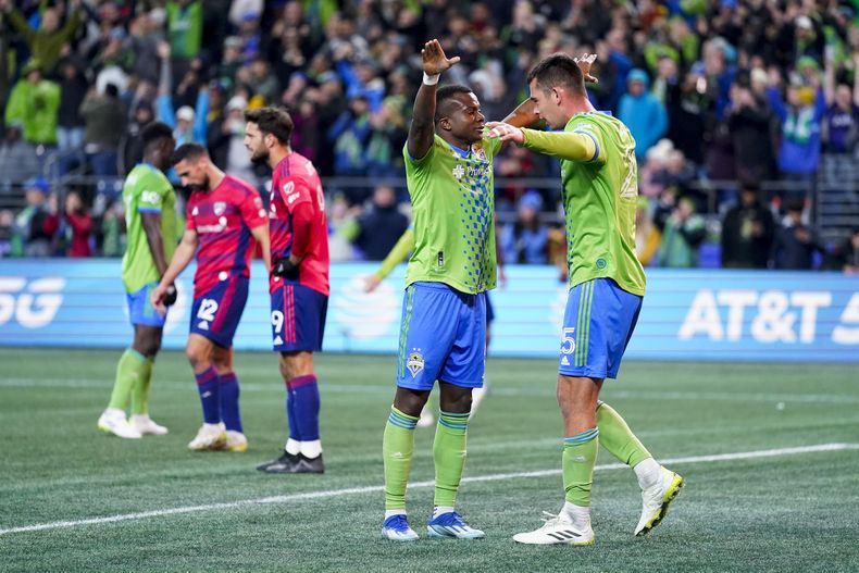 Nouhou Tolo (izquierda), de los Sounders de Seattle, abraza a su compañero Jackson Ragen, tras la victoria sobre FC Dallas en los playoffs de la MLS, el viernes 10 de noviembre de 2023 (AP Foto/Lindsey Wasson)