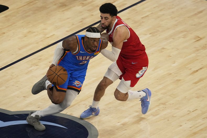 El escolta del Thunder de Oklahoma City, Shai Gilgeous-Alexander (2), regatea el balón ante el escolta de los Grizzlies de Memphis, Scotty Pippen Jr., a la derecha, durante la segunda mitad del Juego 4 de una serie de playoffs de primera ronda de baloncesto de la NBA, el sábado 26 de abril de 2025, en Memphis, Tennessee. (AP Foto/George Walker IV)
