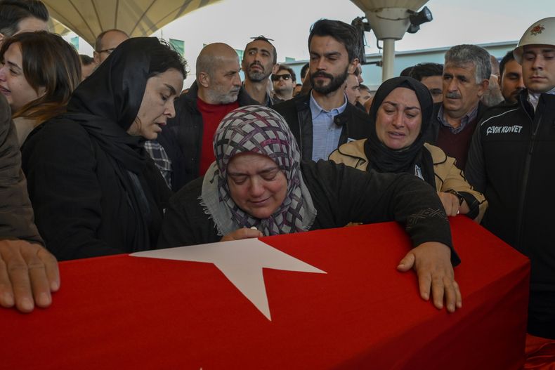 Los familiares de Hasan Huseyin Canbaz, quien murió durante un ataque de milicianos kurdos en la empresa aeroespacial y de defensa turca TUSAS en Ankara el miércoles, lloran durante su funeral en la morgue de Karsiyaka en Ankara, Turquía, el jueves 24 de octubre de 2024. (AP Foto/Ali Unal)