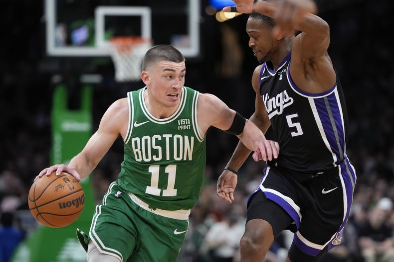 Payton Pritchard, de los Celtics de Boston, elude a DeAaron Fox, de los Kings de Sacramento, en el encuentro del viernes 5 de abril de 2024 (AP Foto/Michael Dwyer)