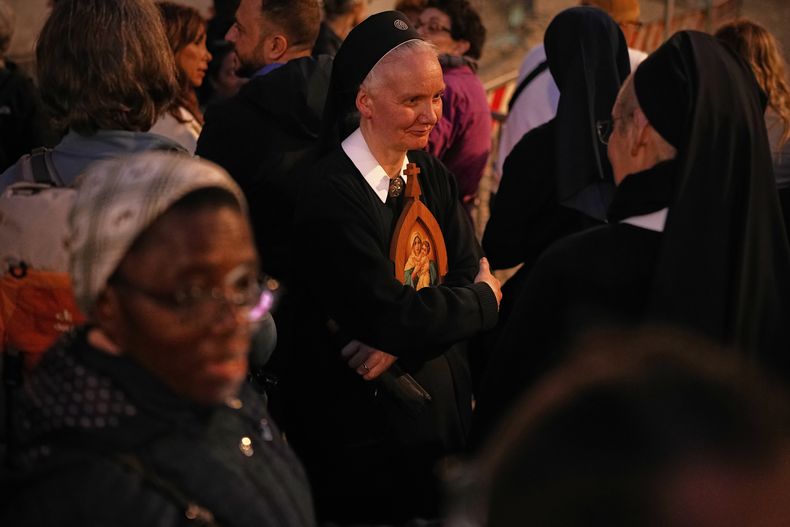 Monjas y peregrinos esperan para rezar un rosario cerca de la basílica de Santa María la Mayor, en donde el papa Francisco será sepultado, el jueves 24 de abril de 2025, en Roma. (AP Foto/Andreea Alexandru)
