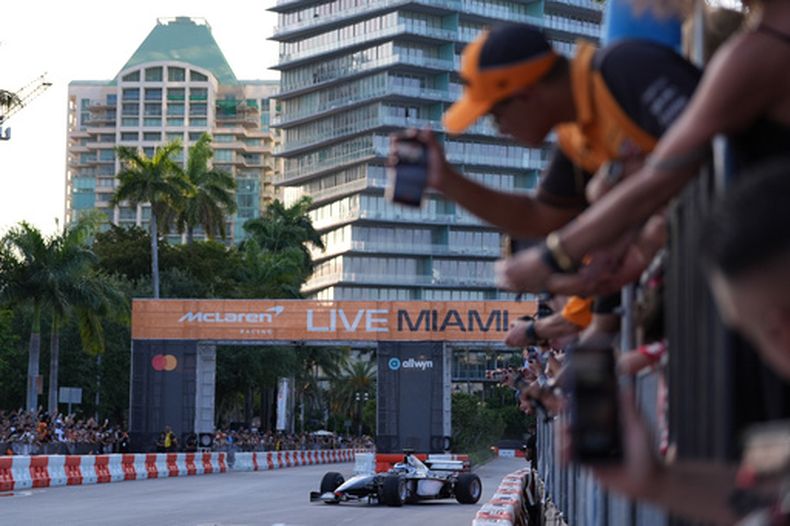Aficionados observan al piloto de F1 Bruno Senna maniobra el MP4/6 durante un evento de aficionados junto a los autos de carrera de McLaren en el Gran Premio de Miami el jueves 29 de abril del 2026. (AP Foto/Rebecca Blackwell)