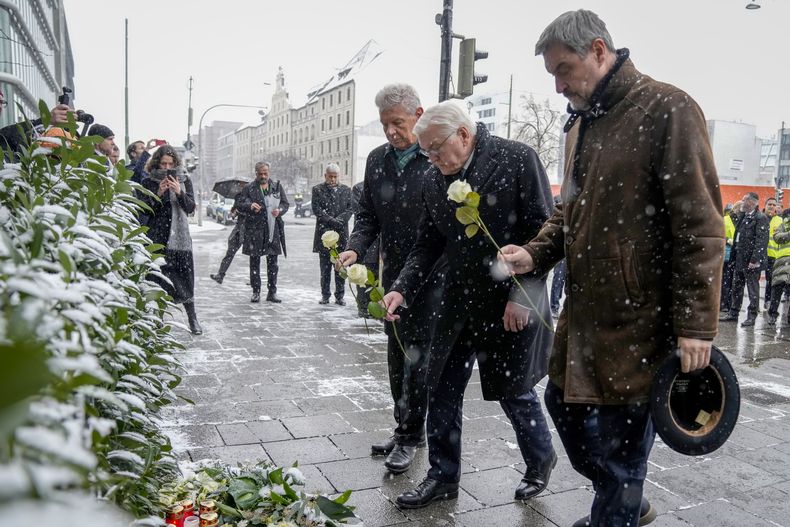 De izquierda a derecha, el primer ministro de Baviera, Markus Soeder; el presidente de Alemania, Frank-Walter Steinmeier, y el alcalde de Múnich, Dieter Reiter, depositan flores en el lugar donde una camioneta se estrelló contra una manifestación de Ver.di en la víspera, el Múnich, Alemania, el 14 de febrero de 2025. (AP Foto/Ebrahim Noroozi)
