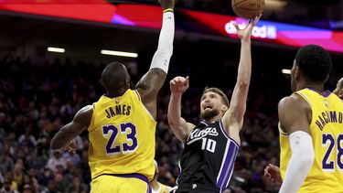 Domantas Sabonis (10), de los Kings de Sacramento, toma un disparo ante la presión de LeBron James (23), de los Lakers de Los Ángeles, durante la segunda mitad del juego de baloncesto de la NBA, en Sacramento, California, el miércoles 3 de marzo de 2024. (AP Foto/Jed Jacobsohn)