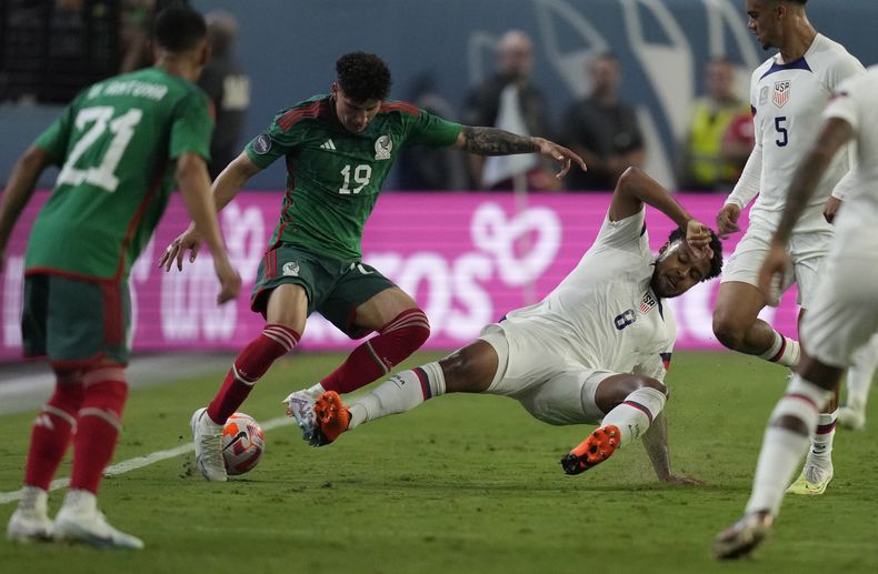 Jorge Sánchez, de México, izquierda, y Weston McKennie, de Estados Unidos, disputan un balón durante la primera mitad de la semifinal de la Liga de Naciones de CONCACAF, el jueves 15 de junio de 2023, en Las Vegas. (AP Foto/John Locher)