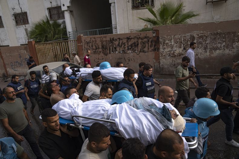 Palestinos, entre ellos algunos periodistas, cargan el martes 10 de octubre de 2023 los cuerpos de dos reporteros palestinos, Mohammed Soboh y Said al-Tawil, quienes murieron por un ataque aéreo israelí en la Ciudad de Gaza. Hamas, el grupo islamista que gobierna la Franja de Gaza, llevó a cabo un ataque sin precedentes el sábado contra Israel, donde mató a más de 1.000 personas y secuestró a varias más. Israel respondió con intensos bombardeos contra Gaza que han dejado a cientos de palestinos muertos. (AP Foto/Fatima Shbair)