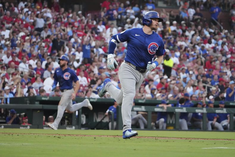 Ian Happ, derecha, de los Cachorros de Chicago, se enfila hacia primera con un sencillo productor de dos carreras, mientras su compañero de equipo Matt Shaw, izquierda, va rumbo al plato para anotar durante la cuarta entrada del juego de béisbol de Grandes Ligas contra los Cardenales de San Luis, el miércoles 25 de junio de 2025, en San Luis. (AP Photo/Jeff Roberson)