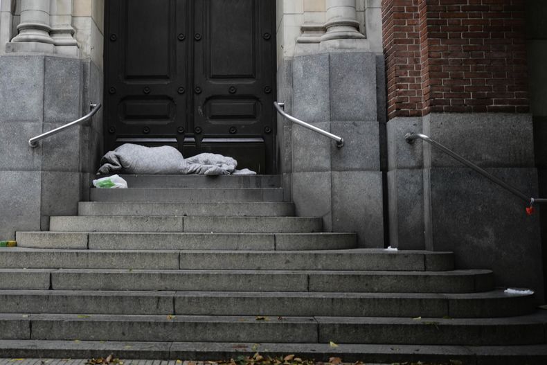 Una persona duerme en las escaleras de una iglesia en Buenos Aires, Argentina, la madrugada del lunes 31 de marzo de 2025. (AP Foto/Natacha Pisarenko)