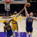 El alero de los Lakers de Los Ángeles Anthony Davis va por el rebote frente a Donte DiVincenzo y Draymond Green de los Warriors de Golden State en el juego 6 de la serie de semifinales de la Conferencia Oeste el viernes 12 de mayo del 2023. (AP Foto/Ashley Landis)