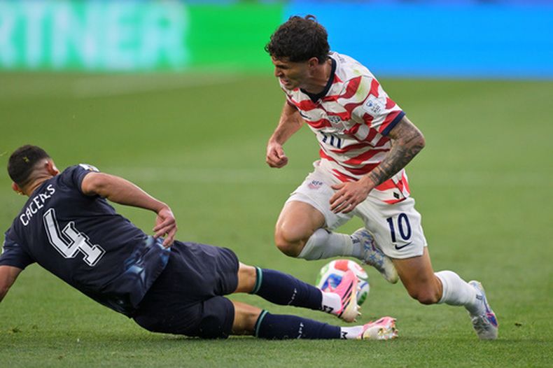 El paraguayo Juan José Cáceres (4) derriba al estadounidense Christian Pulisic (10) durante el partido por el Grupo D del Mundial, el viernes 12 de junio de 2026, en Inglewood, California. (AP Foto/Jayne Kamin-Oncea)