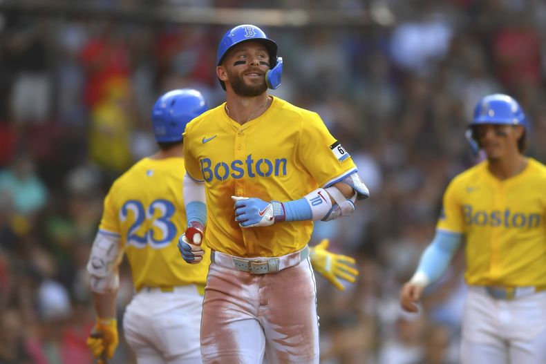 Trevor Story de los Medias Rojas de Boston, al frente, regresa al dugout después de anotar con su jonrón de tres carreras en la tercera entrada de un juego de béisbol contra los Marlins de Miami, el sábado 16 de agosto de 2025, en Boston. (Foto/Steven Senne)