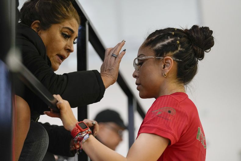 La mexicana Paola Longoria (derecha) recibe la bendición de su madre Leticia López previo a la final de singles ante su compatriota Montserrat Mejía en el ráquetbol de los los Juegos Panamericanos en Santiago, Chile, el martes 24 de octubre de 2023. (AP Foto/Esteban Félix)