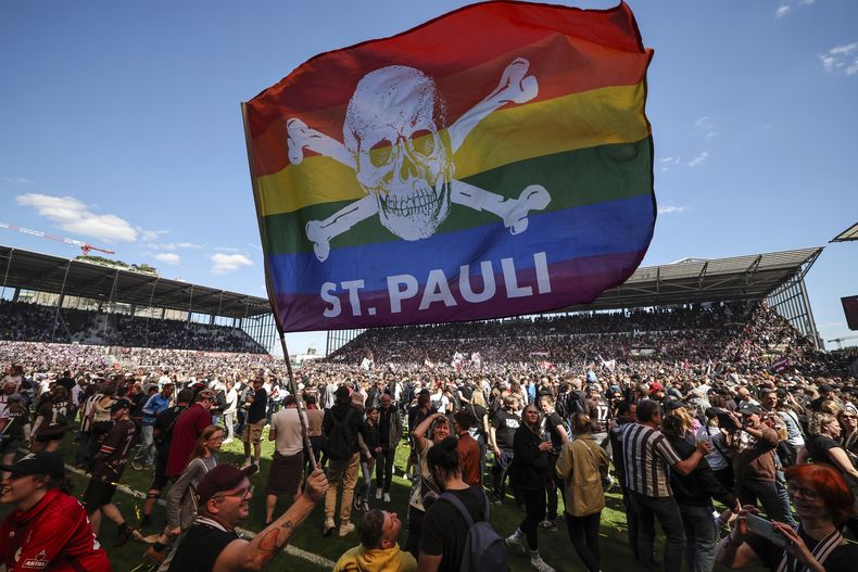 ARCHIVO - Los hinchas de St. Pauli irrumpen en la cancha tras lograr el ascenso a la Bundesliga, primera división de Alemania, el 12 de mayo de 2024, en Hamburgo. (Christian Charisius/dpa vía AP)