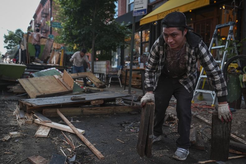 Unos trabajadores derriban una estructura para comer al aire libre frente al restaurante Bricolage, el miércoles 31 de julio de 2024, en el barrio neoyorquino de Brooklyn. (Foto AP/John Minchillo)