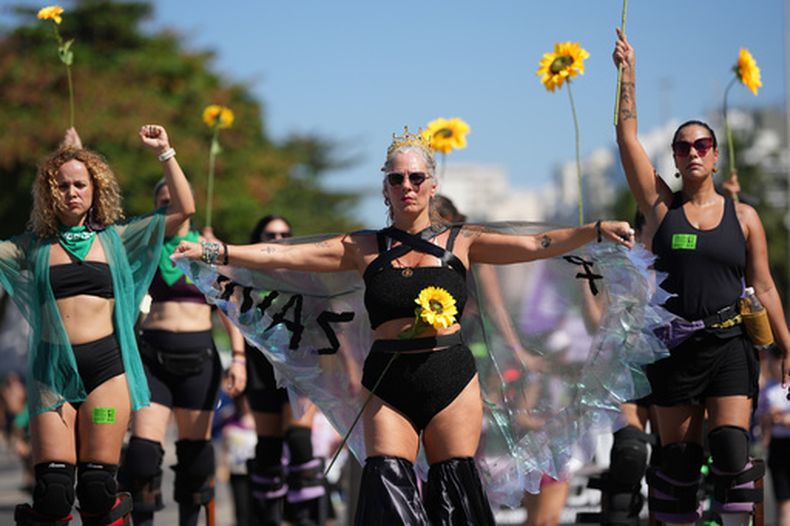 Mujeres protestan en la playa de Copacabana a favor de leyes más sólidas para combatir la misoginia y el feminicidio, el domingo 2 de agosto de 2026, en Río de Janeiro. (AP Foto/Silvia Izquierdo)