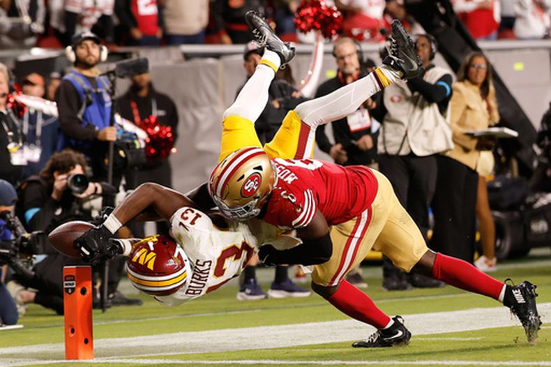 El receptor abierto de los Commanders de Washington, Treylon Burks (13), no logra atrapar un pase mientras es defendido por el safety de los 49ers de San Francisco, Malik Mustapha (6), durante la segunda mitad de un partido de fútbol americano de la NFL en Santa Clara, California, el lunes 19 de octubre de 2026. (Foto AP/Kelley L. Cox)