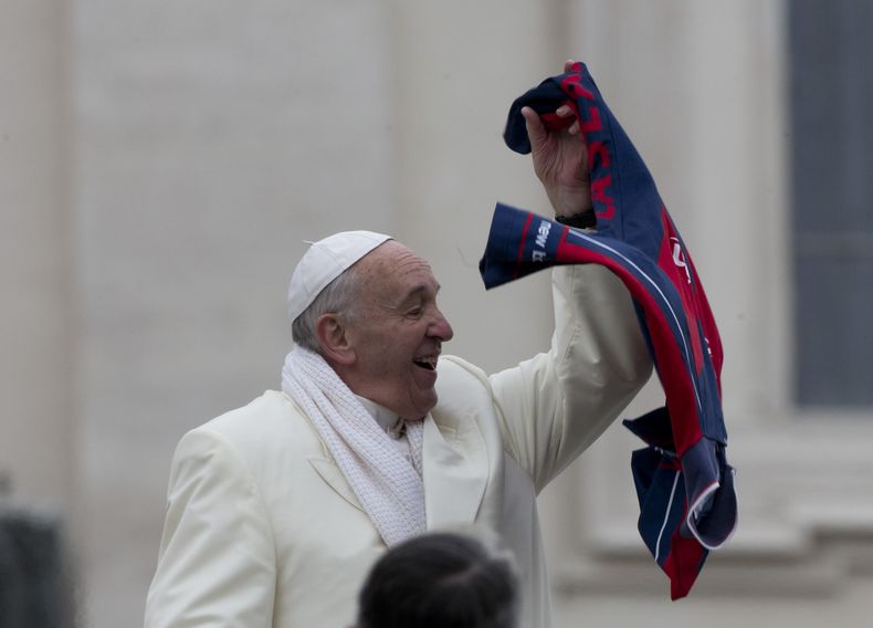 El papa Francisco agita una camiseta que le lanzaron desde la multitud al cabo de su audiencia general semanal en San Pedro, Vaticano, 27 de noviembre de 2013. Francisco design&oacute; a su secretario personal, monse&ntilde;o Alfred Xuereb, el jueves 28 d