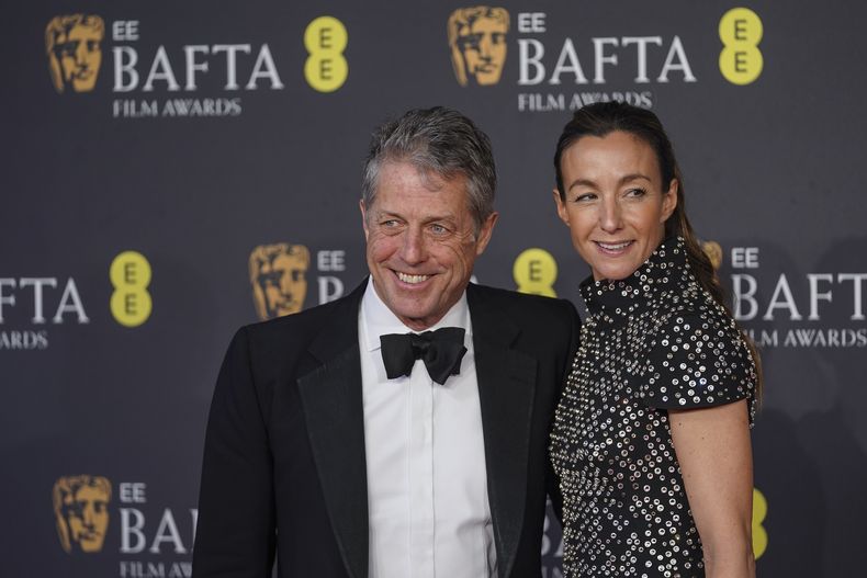 Hugh Grant, izquierda, y Anna Elisabet Eberstein posan a su llegada a la 78a edición de los Premios de la Academia Británica de Cine, BAFTA, en Londres, el domingo 16 de febrero de 2025. (Foto Alberto Pezzali/Invision/AP)