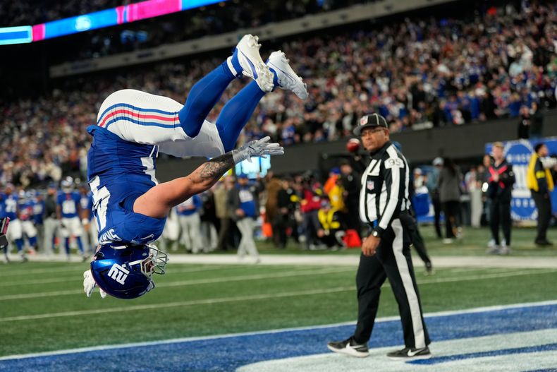Cam Skattebo, de los Giants de Nueva York, realiza un salto mortal tras anotar ante los Eagles de Filadelfia, en el partido del jueves 9 de octubre de 2025 (AP Foto/Seth Wenig)