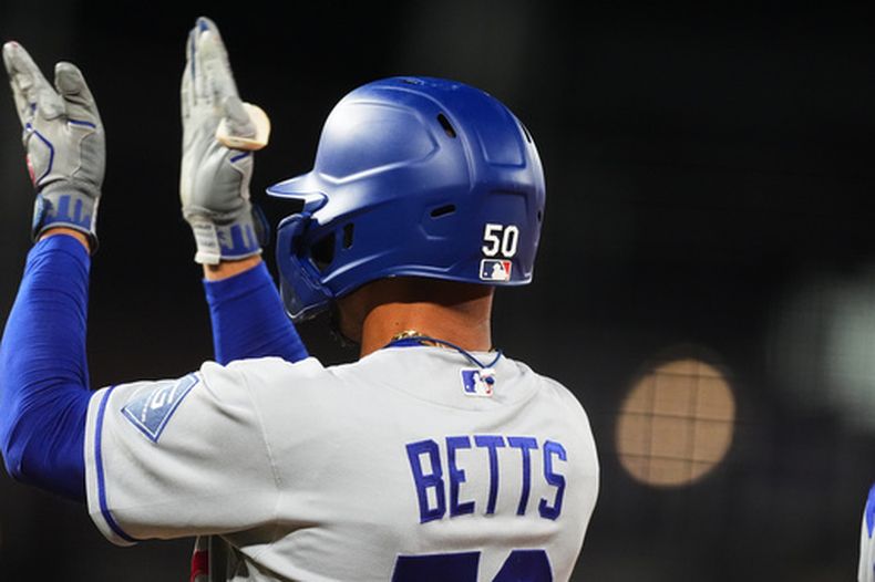 Mookie Betts, de los Dodgers de Los Ángeles, aplaude luego de pegar un sencillo ante los Rockies de Colorado en el encuentro del miércoles 19 de agosto de 2026 (AP Foto/David Zalubowski)