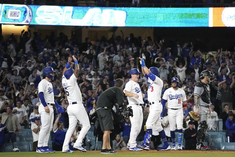 Chris Taylor (3), de los Dodgers de Los Ángeles, recibe la felicitación de David Peralta (6), James Outman (33) y Will Smith (16) tras sacudir un grand slam, ante sus rivales de los Medias Blancas de Chicago Yasmani Grandal (24), en el plato, y Miguel Rojas, en el sexto inning del juego de la MLB que enfrentó a ambos equipos, el 15 de junio de 2023, en Los Ángeles. (AP Foto/Mark J. Terrill)