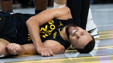Stephen Curry, base de los Warriors de Golden State, yace en la cancha durante el partido ante los Rockets de Houston, el miércoles 26 de noviembre de 2025 (AP Foto/Benjamin Fanjoy)