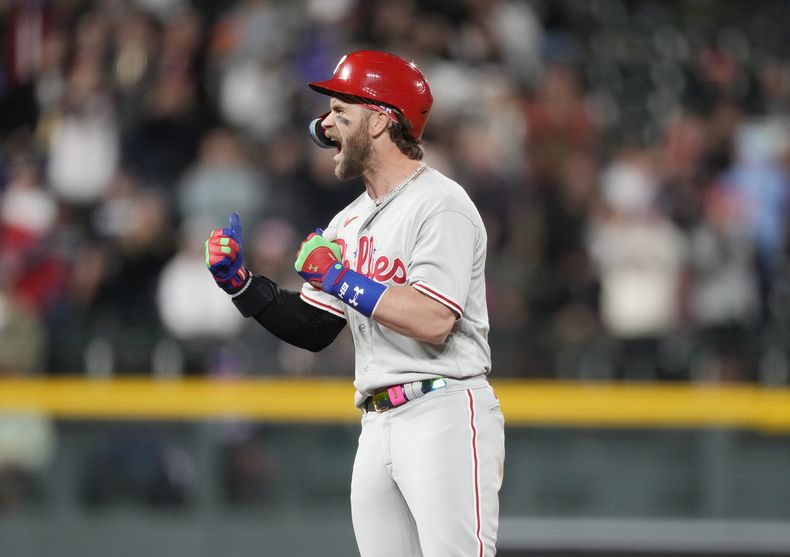 Bryce Harper, de los Filis de Filadelfia, festeja luego de conectar un doble de dos carreras en el juego del viernes 12 de mayo de 2023, ante los Rockies de Colorado (AP Foto/David Zalubowski)