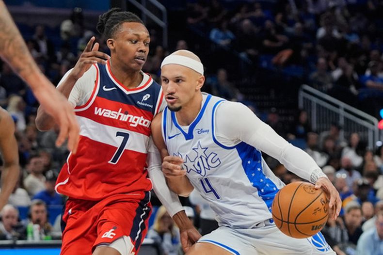 El base del Magic de Orlando Jalen Suggs avanza con el balón frente a Bub Carrington de los Wizards de Washington el jueves 12 de marzo del 2026. (AP Foto/John Raoux)