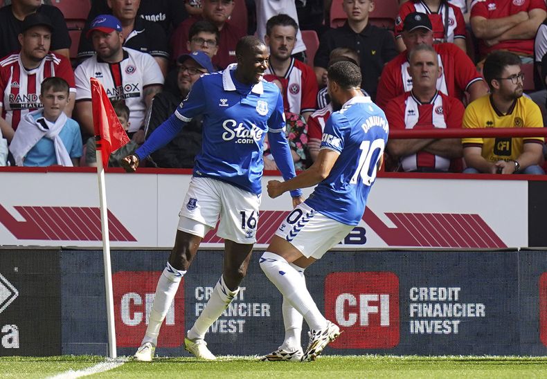 Abdoulaye Doucoure, izquierda, de Everton, celebra con su compañero de equipo Arnaut Danjuma después de anotar el primer gol de la temporada de su equipo en el partido de la Liga Premier de Inglaterra en contra de Sheffield United, en Bramall Lane, Sheffield, Inglaterra, el sábado 2 de septiembre de 2023. (Danny Lawson/PA vía AP)